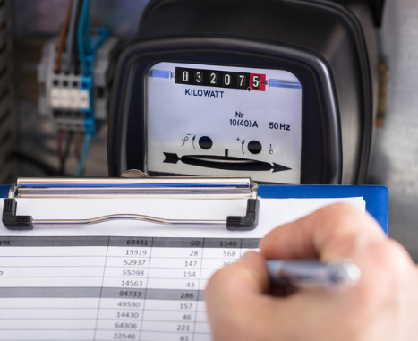 Technician Writing Reading Of Meter On Clipboard