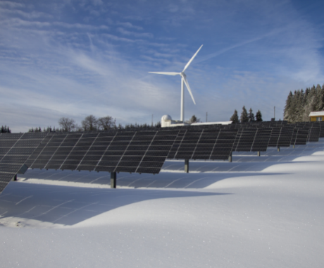 Solar panels and wind turbine on sunny day with snow