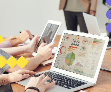 Photograph of employees looking at computers with graphs